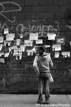 Girl Looking at Postings in Chinatown